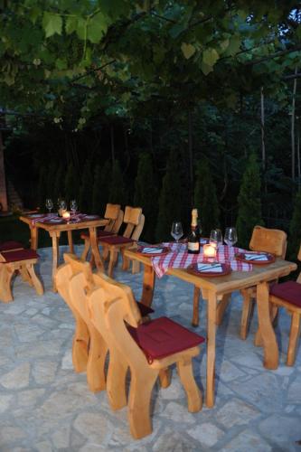 a group of wooden tables and chairs with wine glasses at Apartments Amigo in Kotor