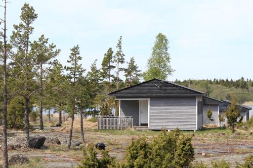 a small house in a field with trees at Eckerö Camping & Stugor in Eckerö