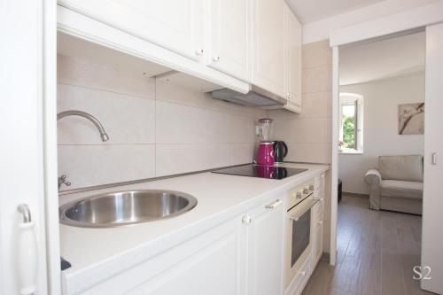 a kitchen with a sink and white cabinets at Morus Alba in Split