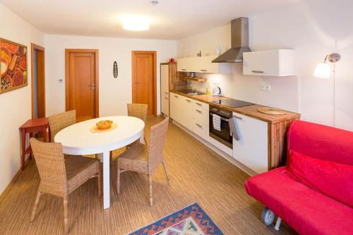 a kitchen and dining room with a table and a red couch at Apartmány Pod náměstím in Telč