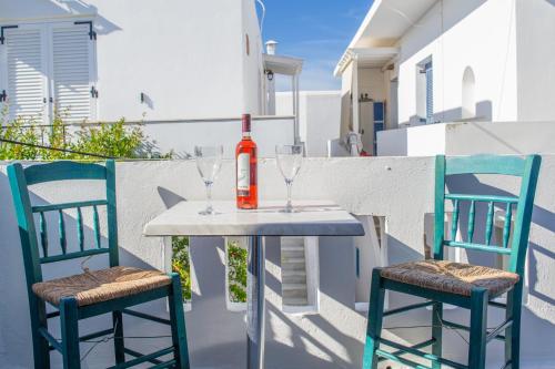a table with two chairs and a bottle of wine at Hotel Antiparos in Antiparos Town