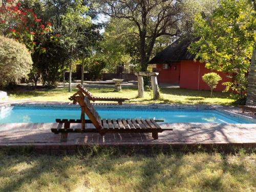 a bench sitting next to a swimming pool at Jump Street Chalets in Maun