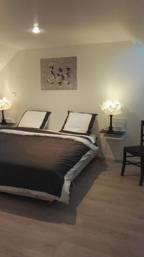une chambre avec un grand lit avec deux lampes dans l'établissement les Bovrieres, à Cysoing