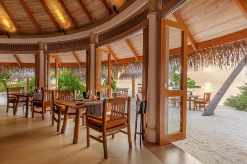 a dining room with tables and chairs in a resort at Milaidhoo Maldives in Baa Atoll