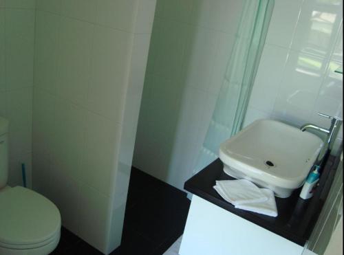 a white bathroom with a sink and a toilet at Villa Tujuh in Senggigi 