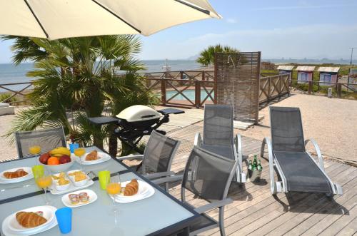 a table with food on a deck with the beach at Arenales del Mar Menor - 9308 in La Manga del Mar Menor