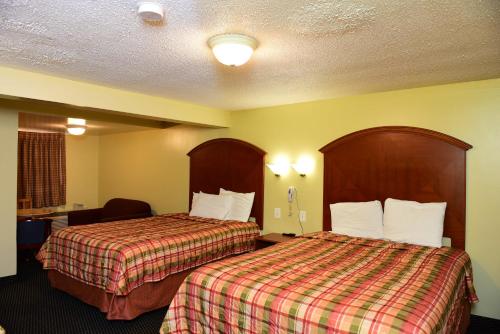 a hotel room with two beds in a room at Royal Inn in Tonawanda