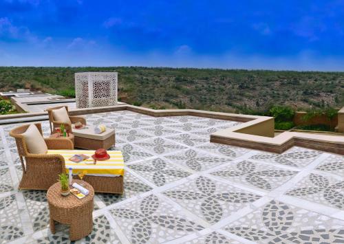a patio with a table and chairs and a view at The Lalit Mangar in Faridabad