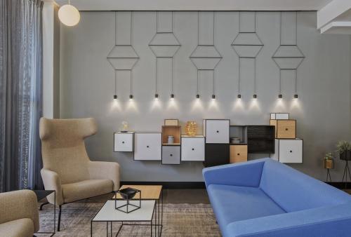a living room with a blue couch and chairs at Prima Tel Aviv Hotel in Tel Aviv