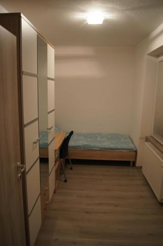 um pequeno quarto com uma cama e uma secretária em Domas RD Apartment em Ljubljana