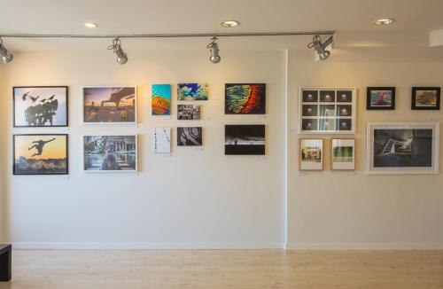 a wall with pictures on it in a gallery at Prima Tel Aviv Hotel in Tel Aviv