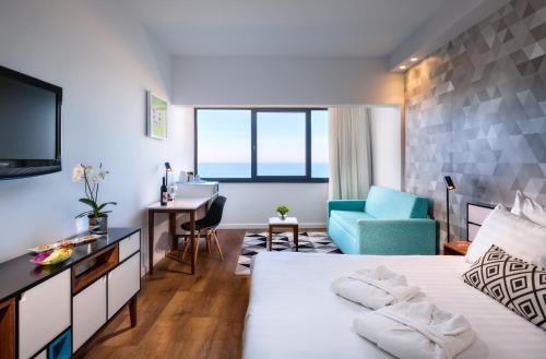 una camera d'albergo con letto e scrivania di Prima Tel Aviv Hotel a Tel Aviv