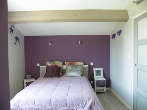 une chambre avec un lit avec un mur violet dans l'établissement Maison de la Mascotte, à Châteaurenard