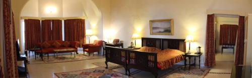 科塔Brijraj Bhawan Palace Hotel的一间带床的卧室和一间客厅