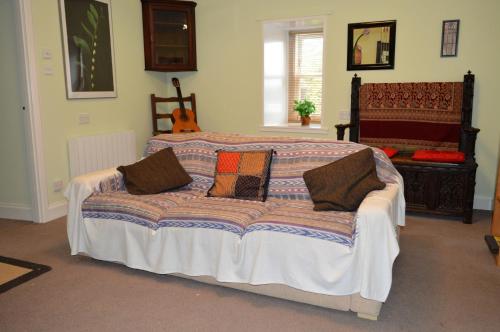 a bedroom with a large bed with pillows on it at Trevenek Cottage in Kilmartin