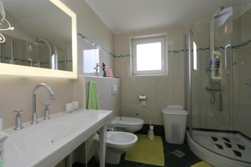 a bathroom with a sink and a toilet and a shower at Apartment Sonja in Klimno