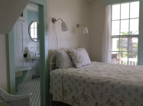 a bedroom with a bed and a window and a sink at Wades Point Inn on the Bay in Saint Michaels