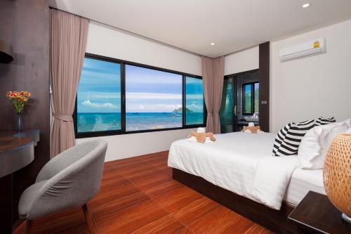 a bedroom with a bed and a view of the ocean at Simple Life Cliff View Resort in Koh Tao