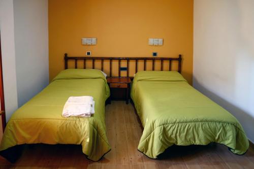 プラセンシアにあるHostal Murallaのベッド2台が隣同士に設置された部屋です。