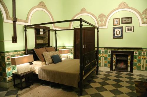Un dormitorio con una cama con dosel y una chimenea. en Raghu Vilas, en Mussoorie