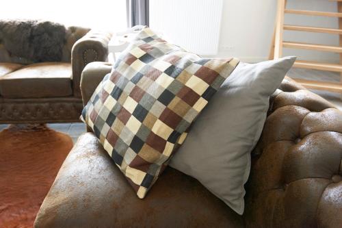 a couch with two pillows on top of it at B&B Barvaux, Durbuy in Durbuy
