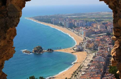 a view of a beach from a window at Central park Blanes in Blanes