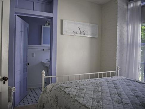 a bedroom with a bed and a window and a door at Wades Point Inn on the Bay in Saint Michaels