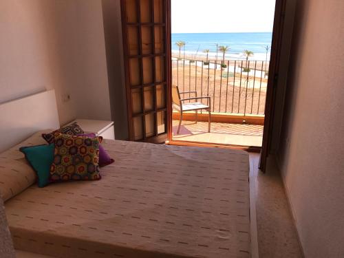 ポルト・サプラヤにあるApartamento PortSaplayaのビーチの景色を望むベッドルーム1室(ベッド1台付)