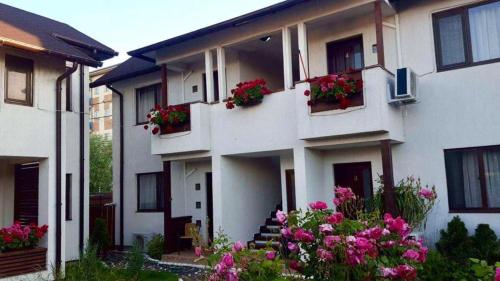 a white house with flowers in the window boxes at Pensiunea Casa Blanca in Sulina