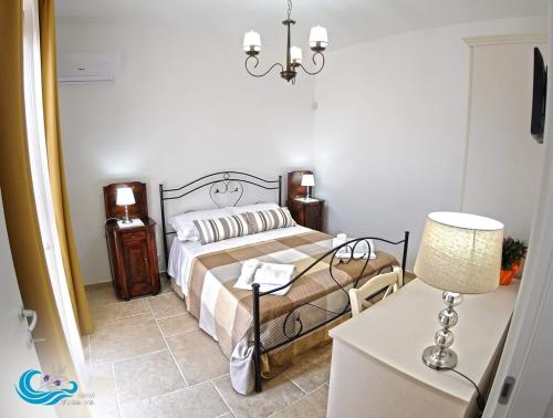 a bedroom with a bed and a table with a lamp at Il Mirto Blu in Porto Cesareo