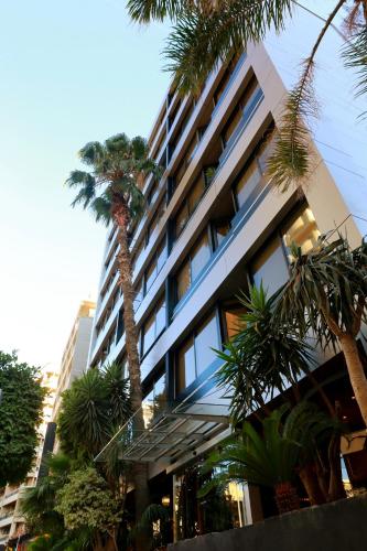 a building with a palm tree in front of it at Imperial Suites Hotel in Beirut