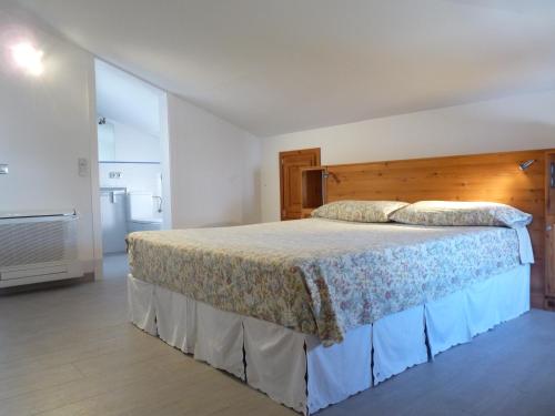 a bedroom with a large bed with a wooden headboard at Sa Lluna in Es Mercadal