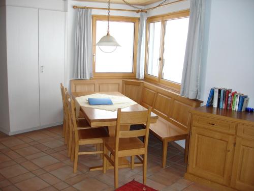 eine Küche mit einem Tisch und Stühlen sowie einem Fenster in der Unterkunft Apartment Weisshorn in Riederalp