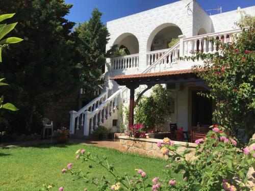 a large white house with a porch and stairs at Studios Irene in Skala