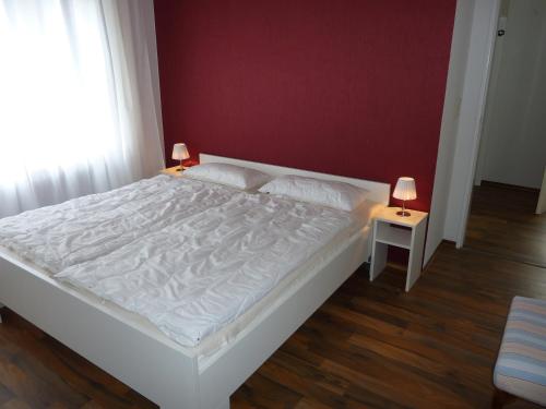 a bedroom with a large white bed and two lamps at meine-nordsee-fewo in Esens