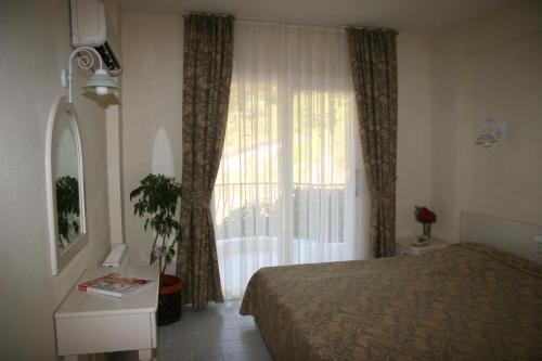 ein Schlafzimmer mit einem Bett und einem großen Fenster in der Unterkunft Life Apart in Marmaris