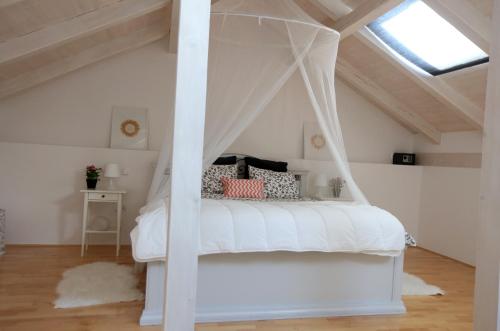 um quarto com uma cama de dossel branca em Kuće za odmor Brkić em Lozovac