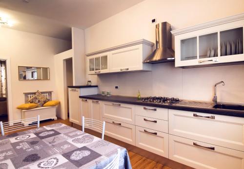 a kitchen with white cabinets and a table in a room at Diamond Apartment in Cattolica