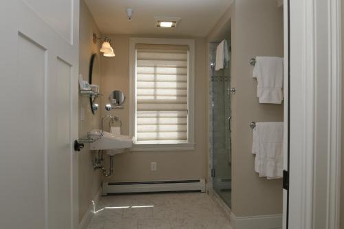 a bathroom with a shower and a sink and a window at The Vermont House in Wilmington