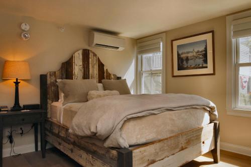 a bedroom with a large bed with a wooden headboard at The Vermont House in Wilmington