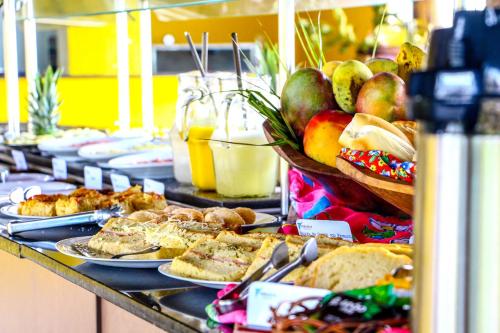 a buffet with plates of food on a table at Makaira Beach Resort in Canavieiras