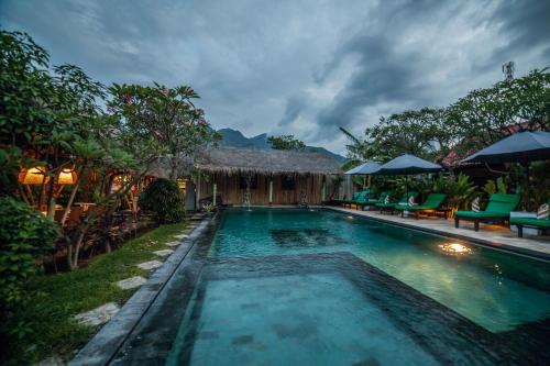 a swimming pool at a resort with at Mans Cottages & Spa in Pemuteran