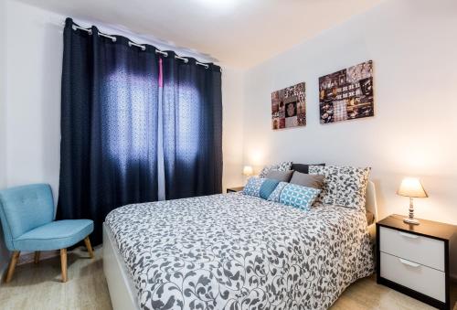 プエルト・デル・カルメンにあるApartment Princesa Bitacoraのベッドルーム1室(ベッド1台、青い椅子付)