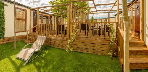 a deck with a chair on the grass at Magic Robin Hood in Albir