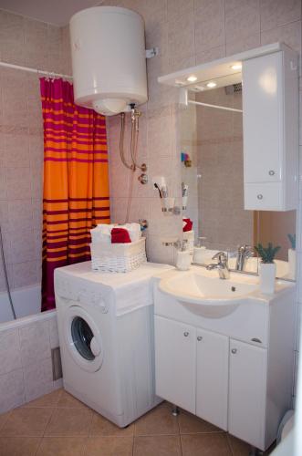 a bathroom with a washing machine and a sink at Apartment A&T Countryside in Čilipi