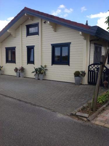 a white house with black windows and a driveway at De Kreek - De Krabbenkreek in Sint Annaland