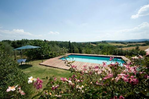 uma piscina num jardim com flores em B&B Il Pettirosso di Siena em Siena