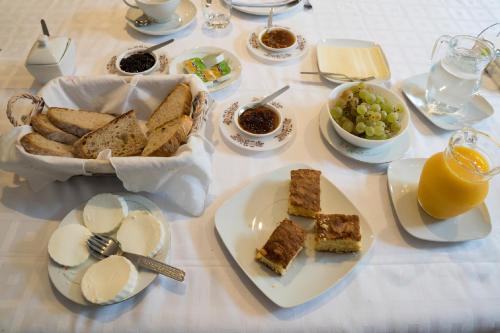 un tavolo con un piatto di pane, uva e succo d'arancia di Casa Da Trigueira a Santa Eugénia