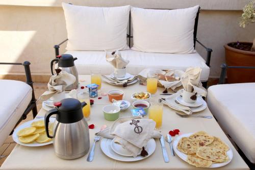 a breakfast table with food and drinks on a bed at Riad La Croix Berbere De Luxe in Marrakech