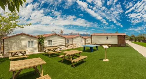 a backyard with picnic tables and benches on a lawn at Magic Robin Hood in Albir